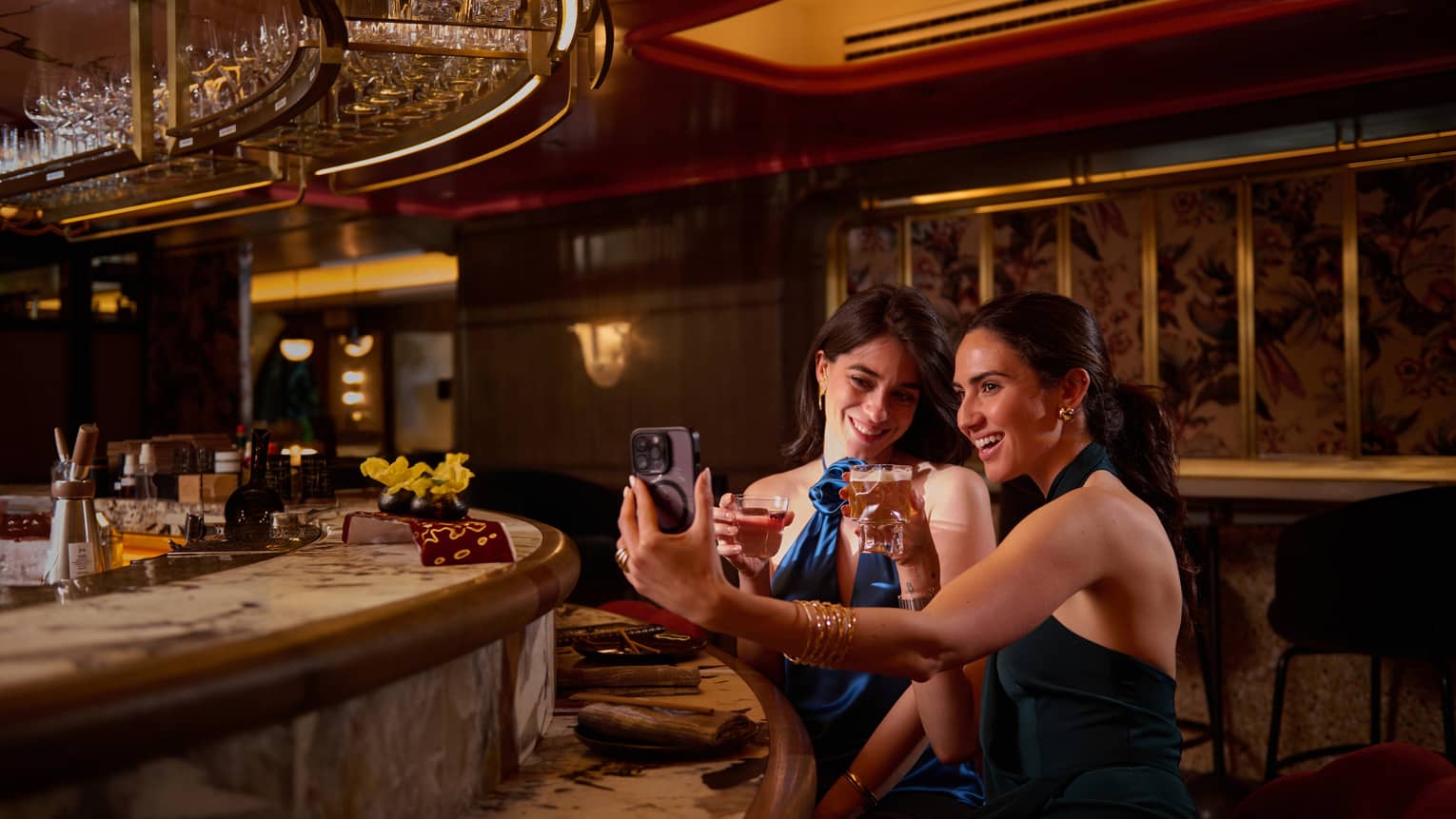 Two women pose for a selfie at bar of Isa Restaurant