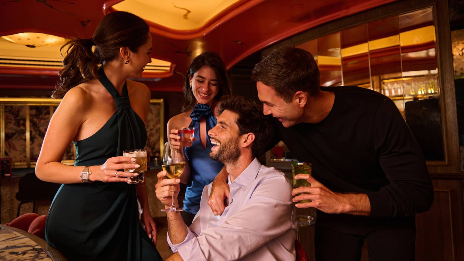 A group of friends laugh over cocktails at Isa Restaurant