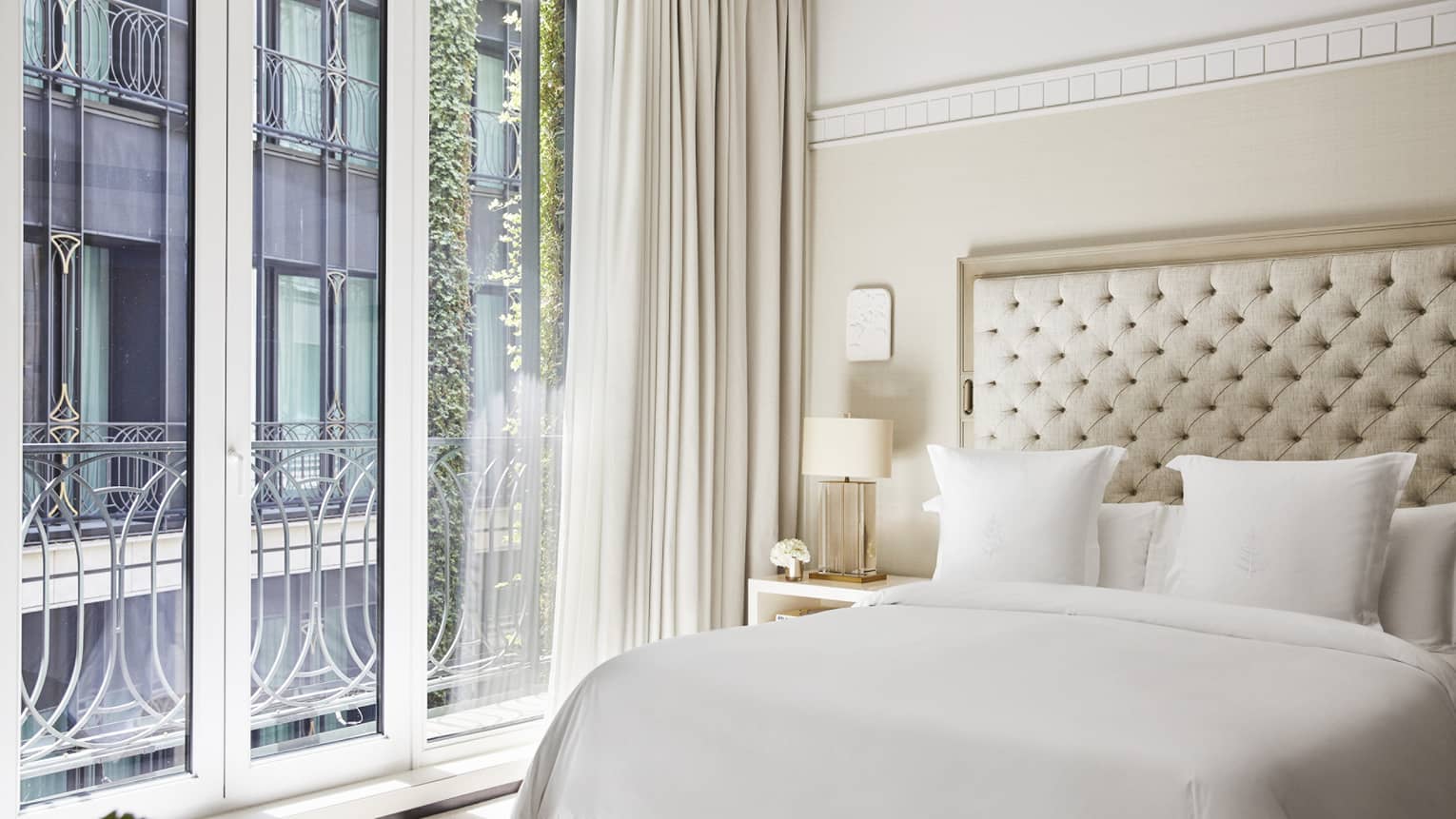 Hotel room with king bed, tufted headboard, Juliet balcony