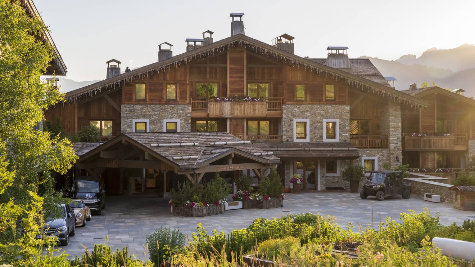 Large chalet surrounded by trees and with mountains in the background