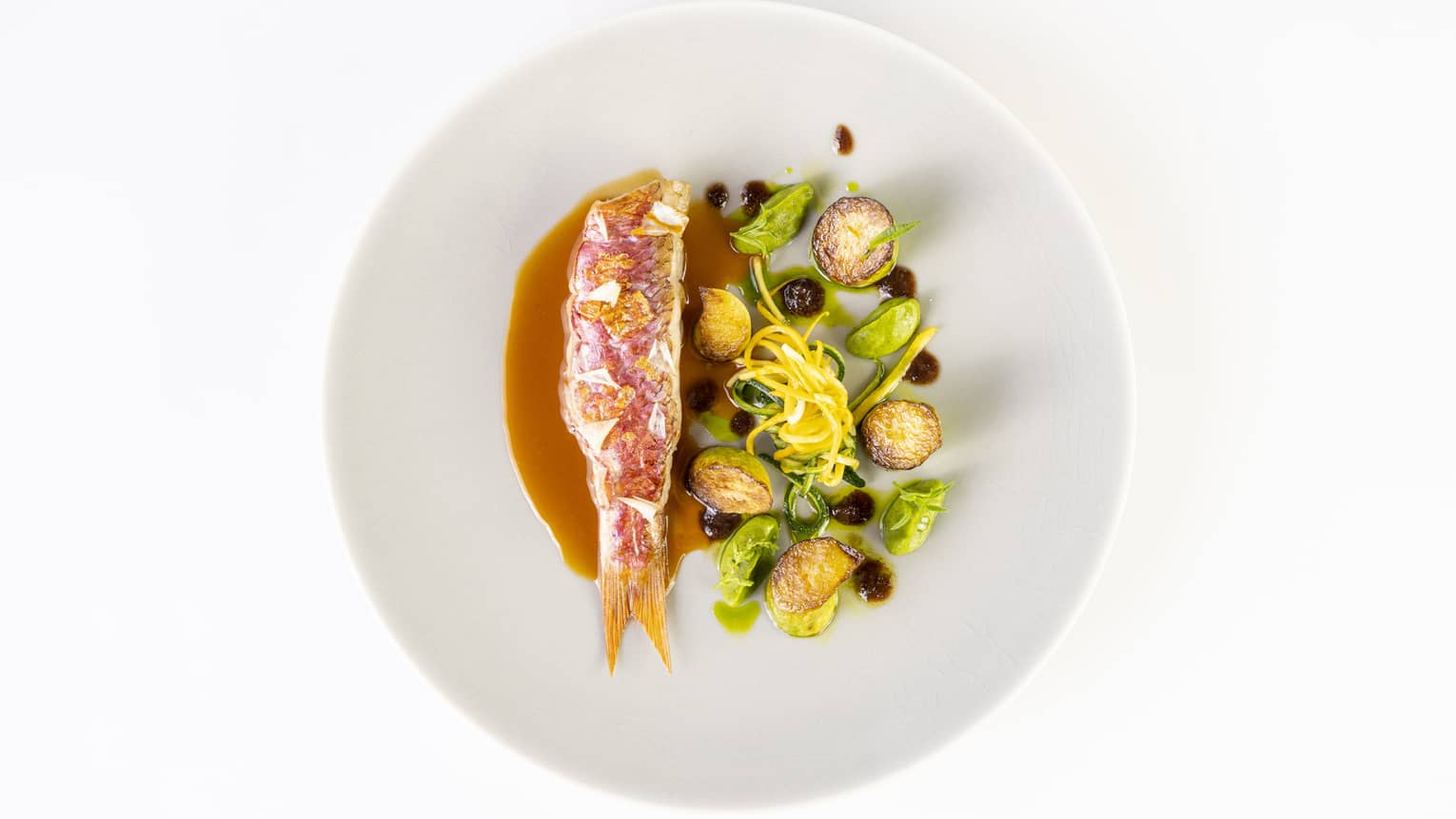 Fish and greens on a white plate.
