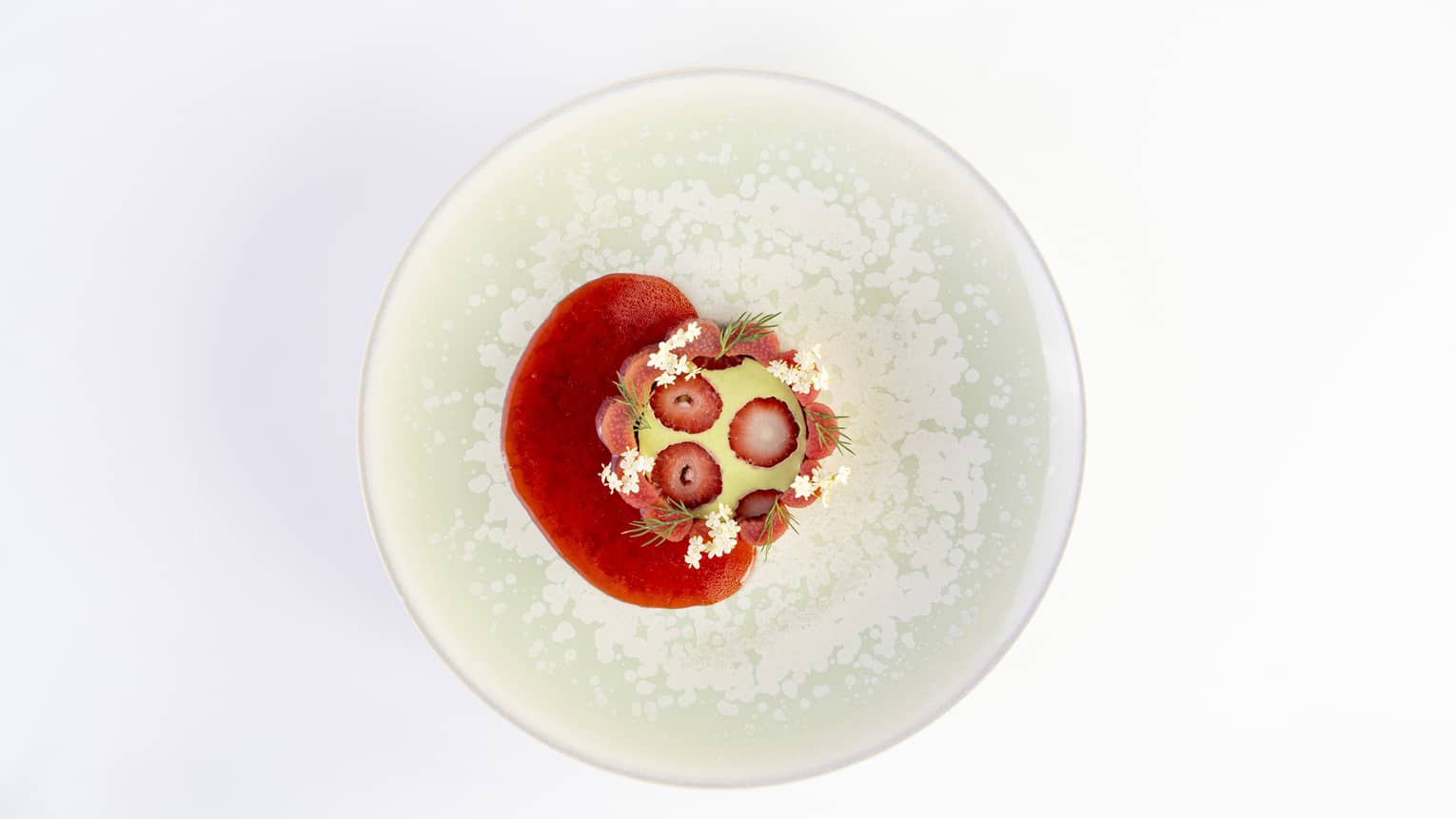 Strawberry and dill on a plate.