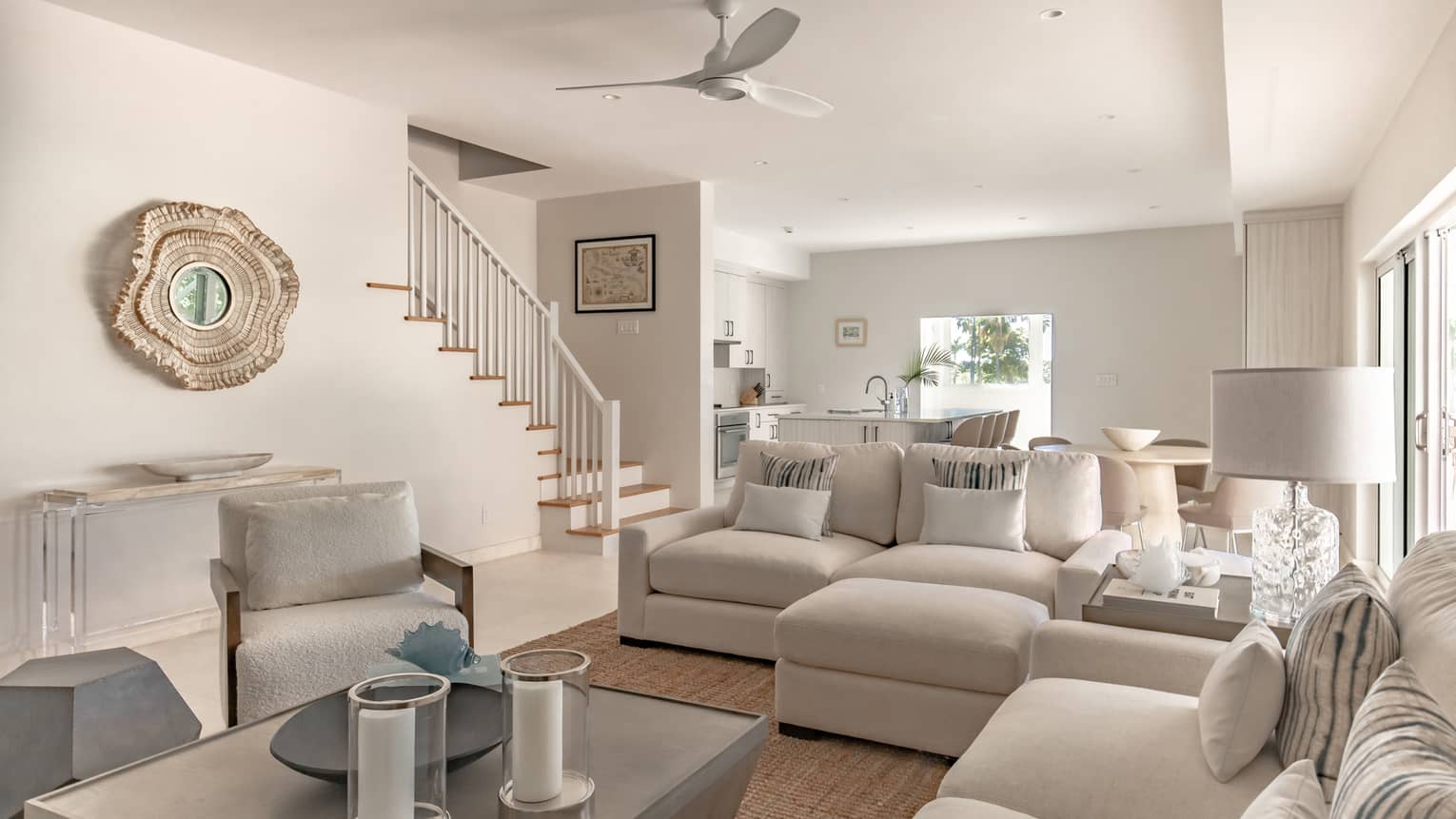 Living room with white sofas and arm chair, white walls and wooden floors
