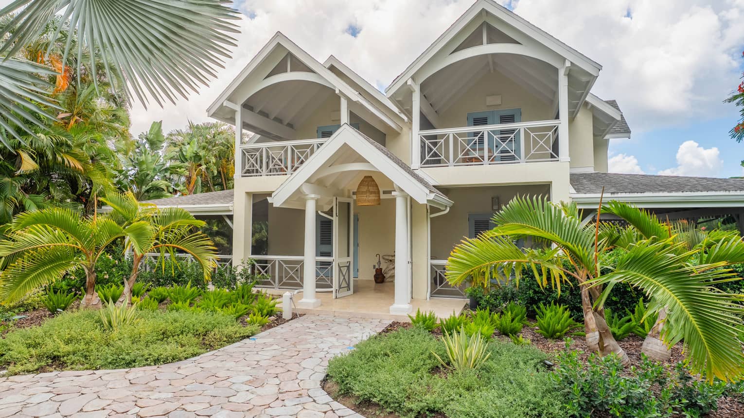 Exterior of a large home in a tropical setting during the day