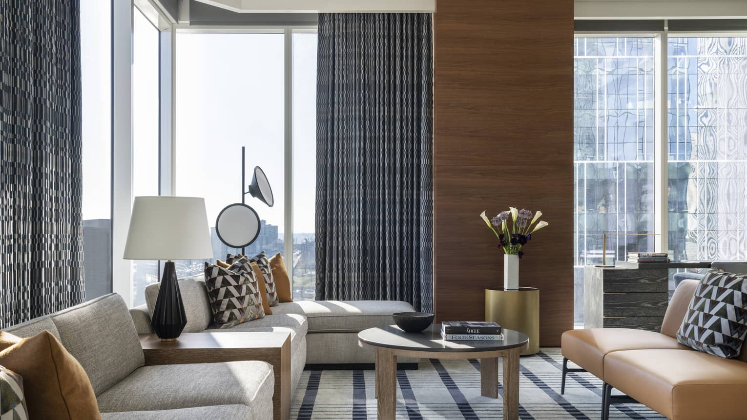 Living room with sectional sofa and tan leather sofa, corner-location with city views