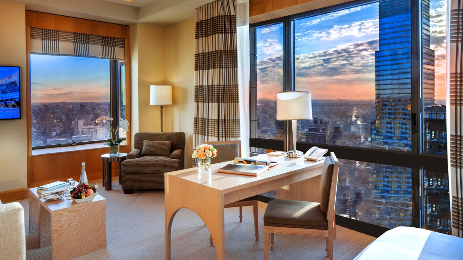 Sunset views from hotel corner windows, desk, armchair, striped curtains