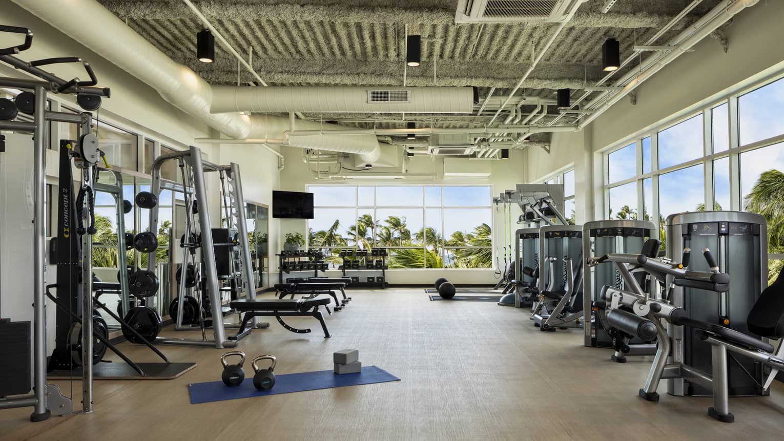 Large light-filled fitness centre with various weight training machines, free weights and cardio machines at Four Seasons Resort Oahu
