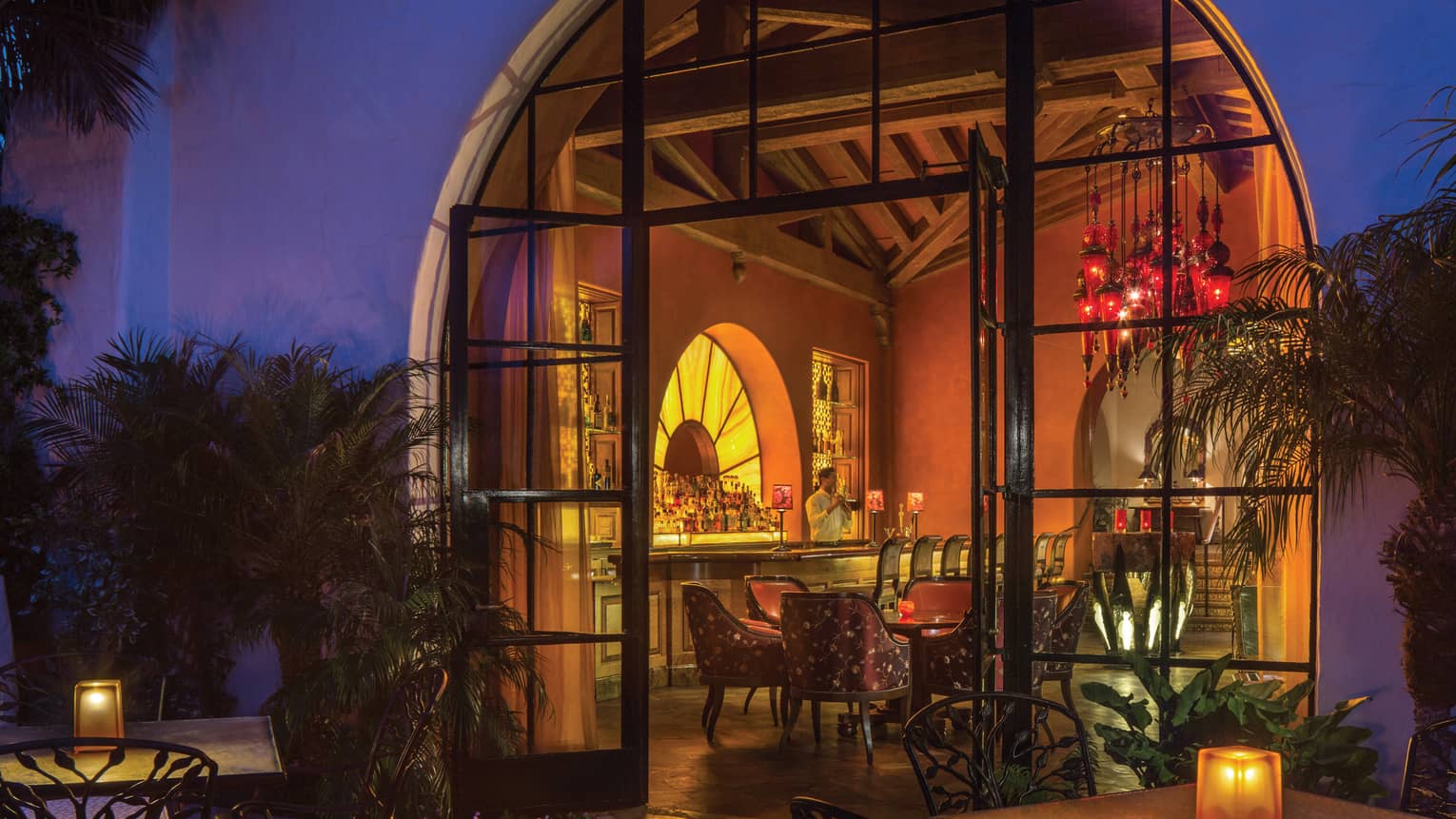 Looking into Ty Lounge through large arched door from patio at dusk