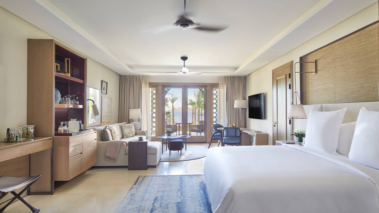 Bedroom with king bed, sitting area and glass doors to patio
