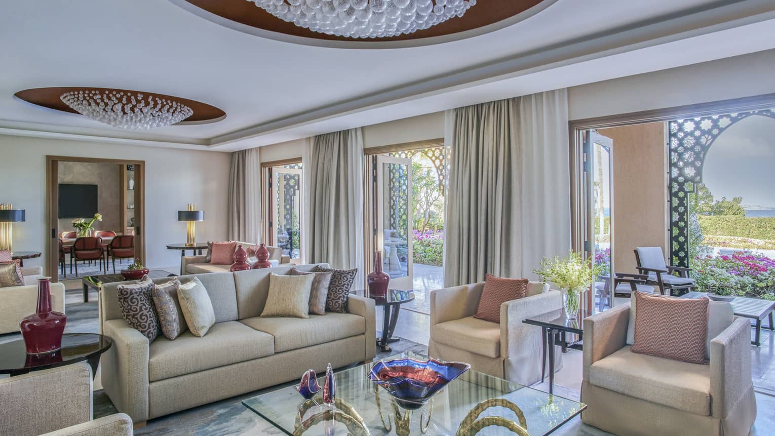Living room with two crystal chandeliers, sofa, four arm chairs and walk-out terrace