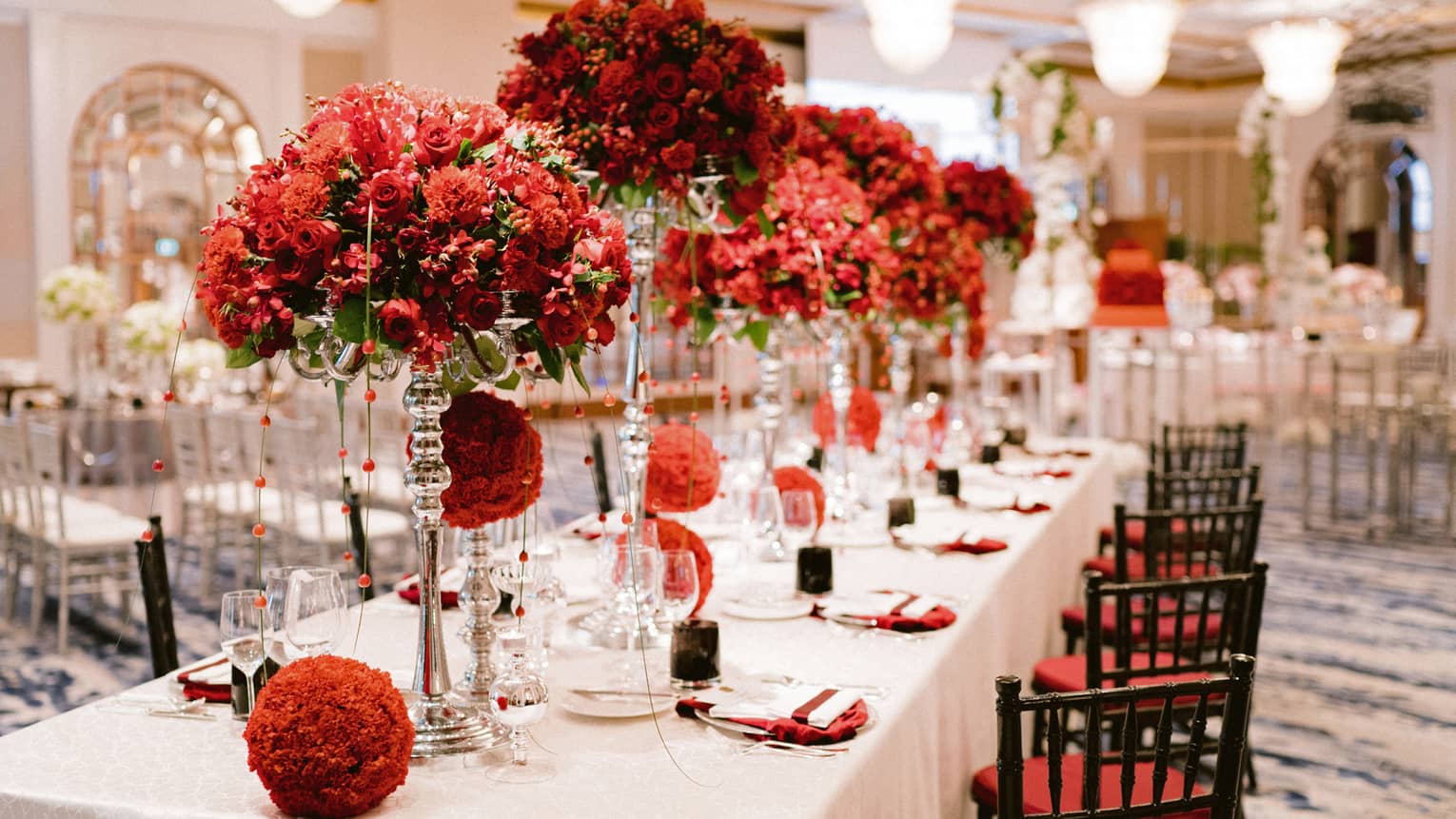 Red flower arrangements on dining table in wedding reception banquet room