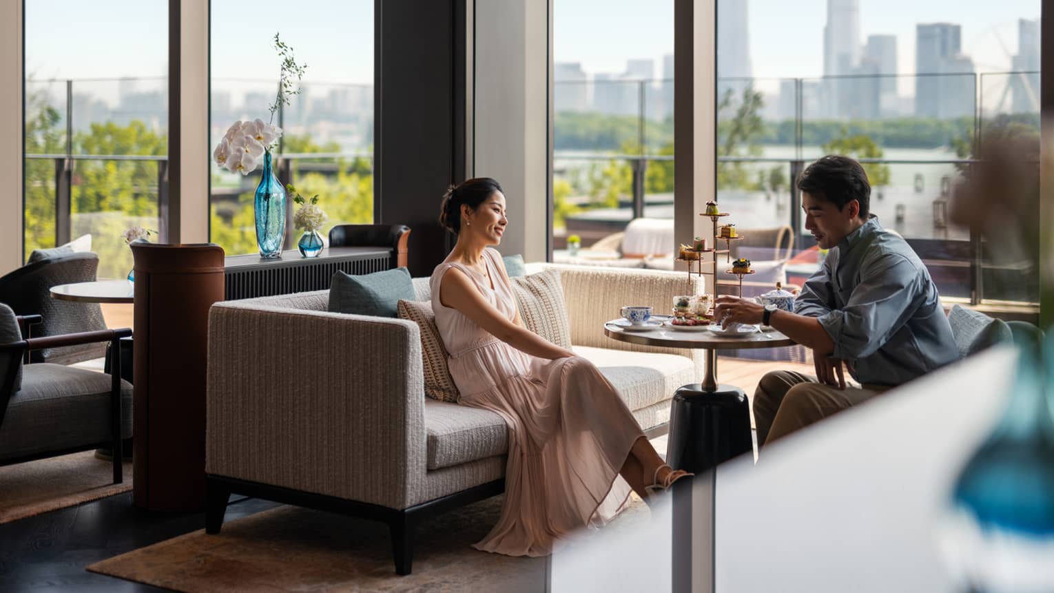 Man and woman enjoy afternoon tea at Lobby Lounge at luxury hotel