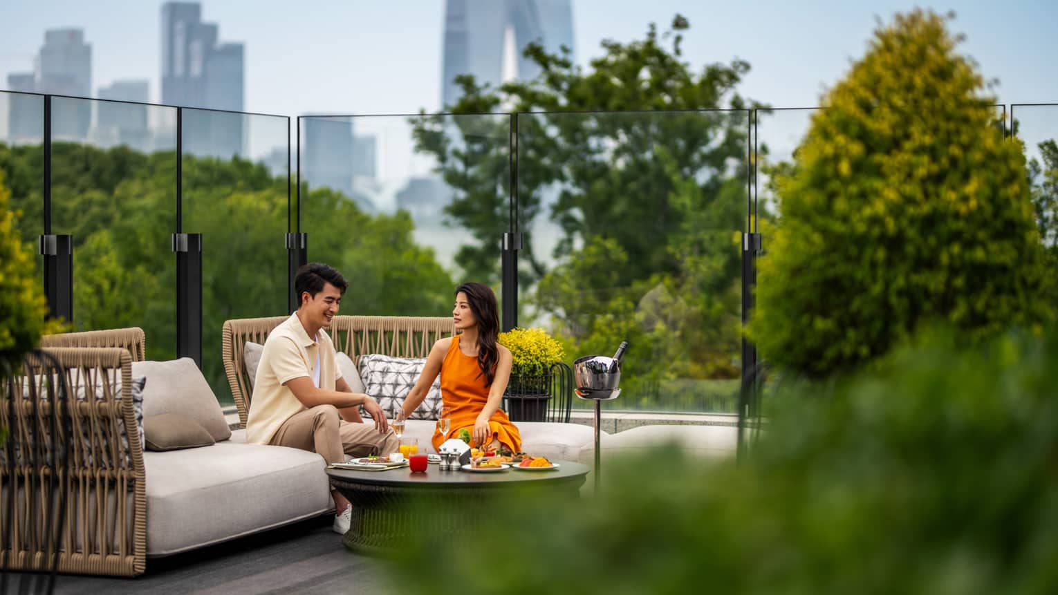 Man and woman dine on Yun He restaurant terrace at Four Seasons Hotel Suzhou, with Suzhou city in background