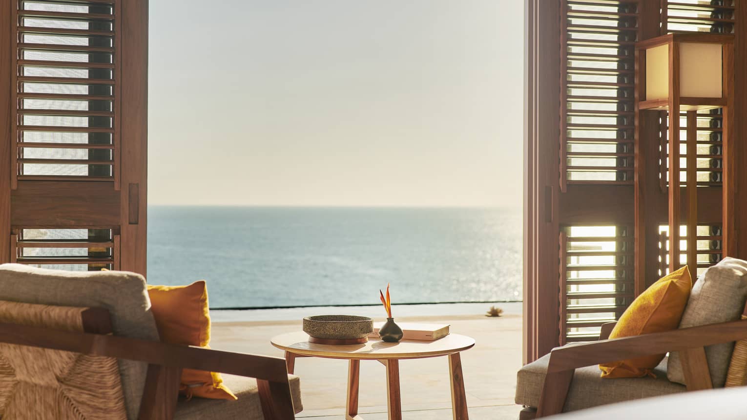 Two chairs facing a walk-out terrace with ocean view