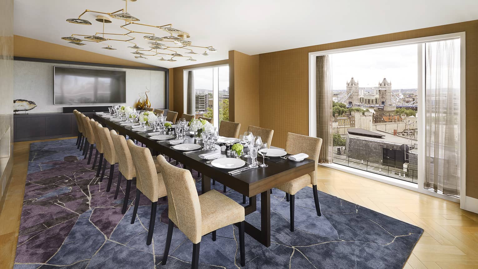 Elegant function space with rectangular conference table set for dinner under modern lighting with views of Tower Bridge