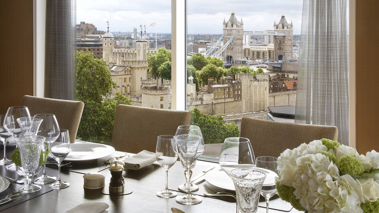 Dining table with white flowers by The Thames Penthouse View window