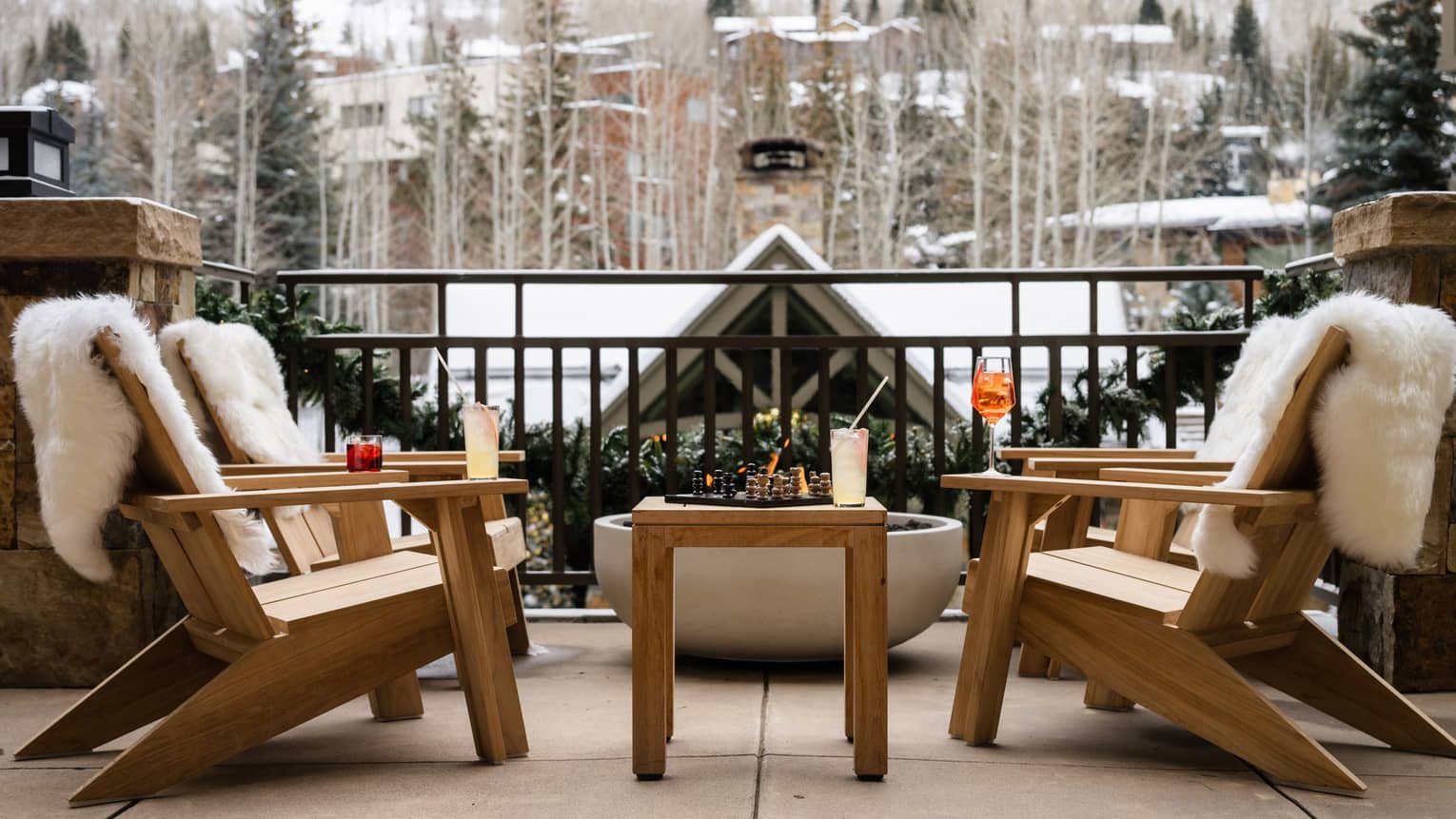 Four chairs on an outdoor terrace near a fire pit
