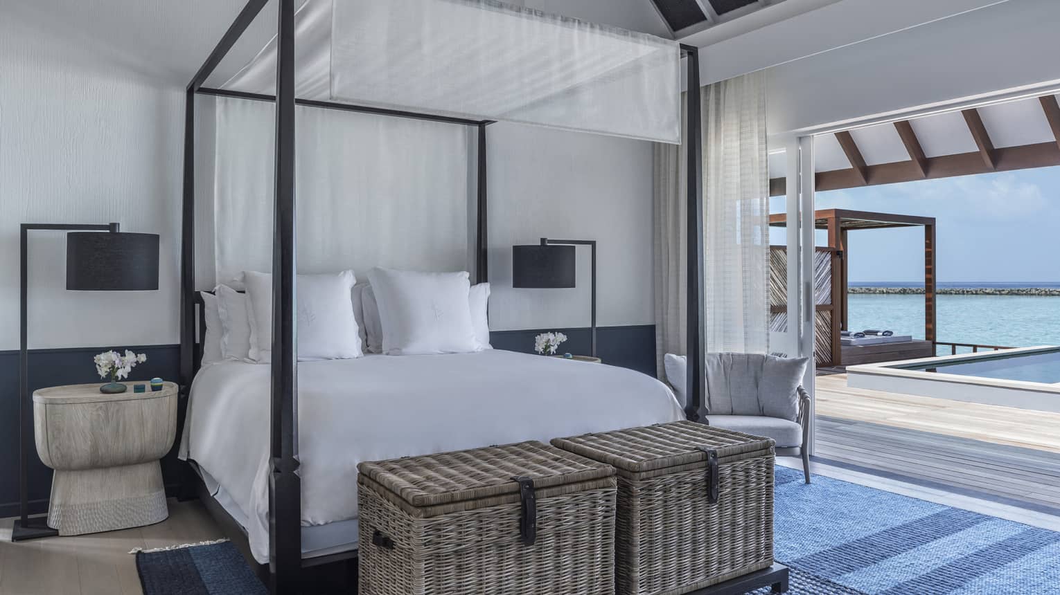 Sunrise Water Villa with Pool bedroom with four-poster bed, doorway opening onto deck with pool