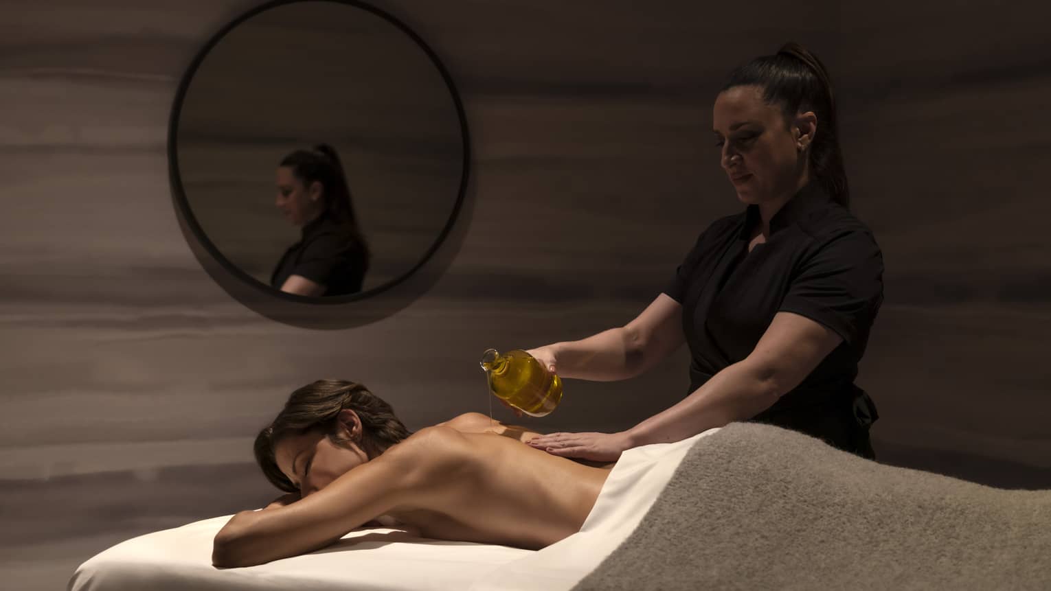 A woman getting a massage in a dimly lit room.