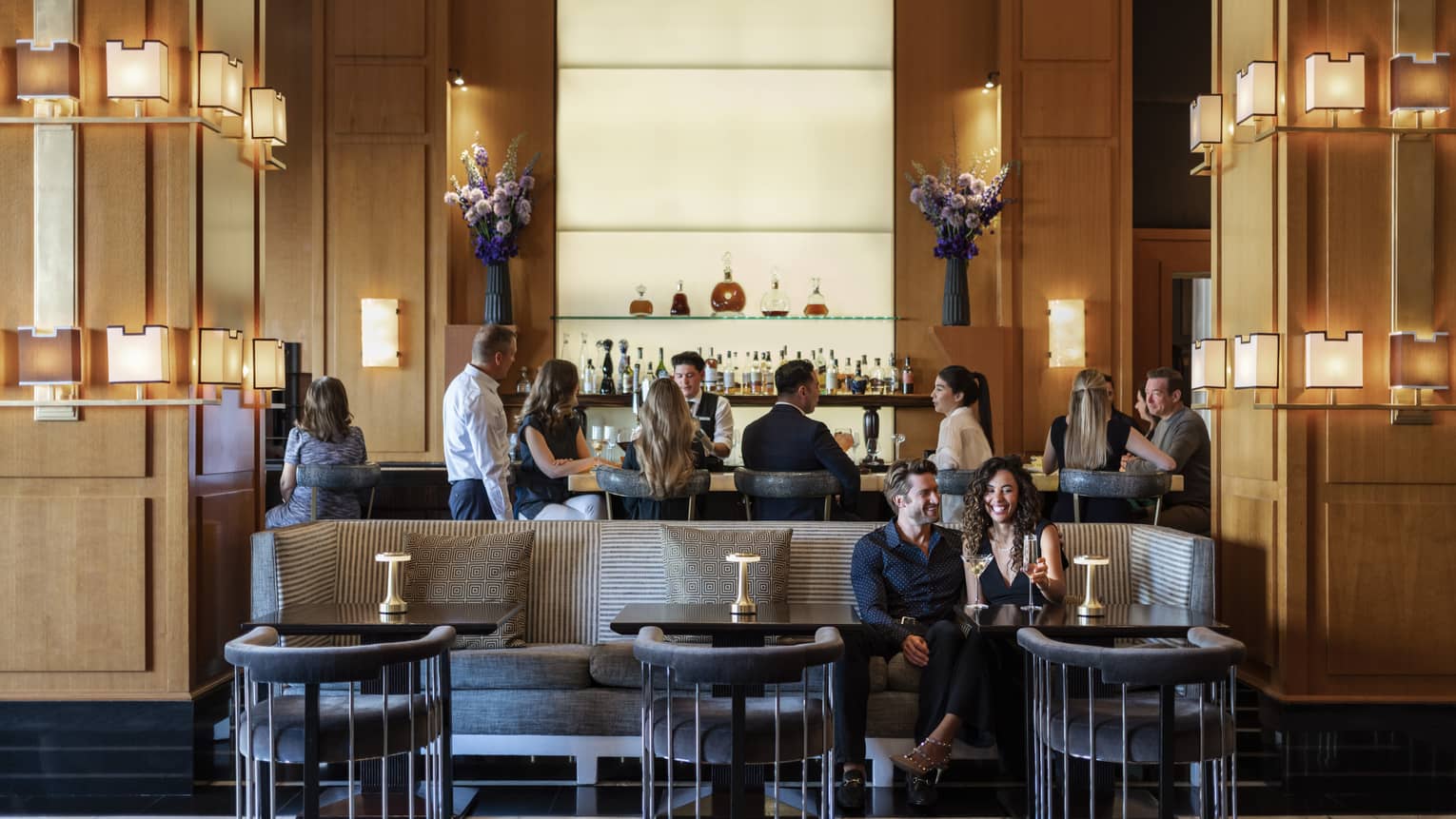 People sitting at a bar and booth in a dining outlet.