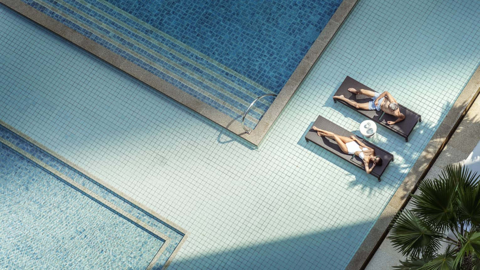 Aerial shot of two women on lounge chairs in pool