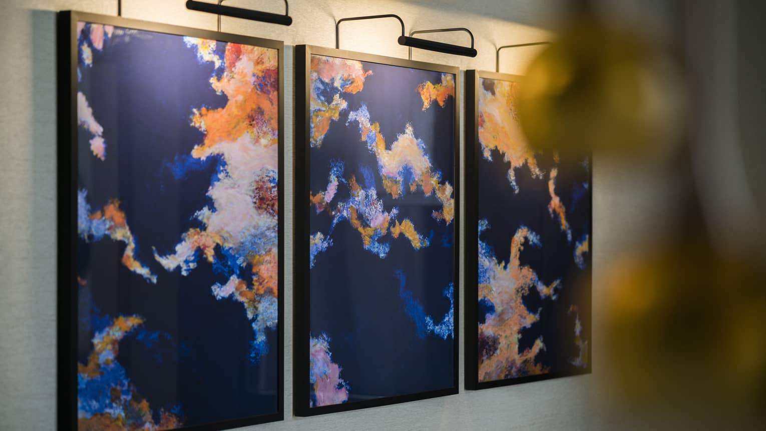 Brightly-coloured, three panel abstract painting on wall