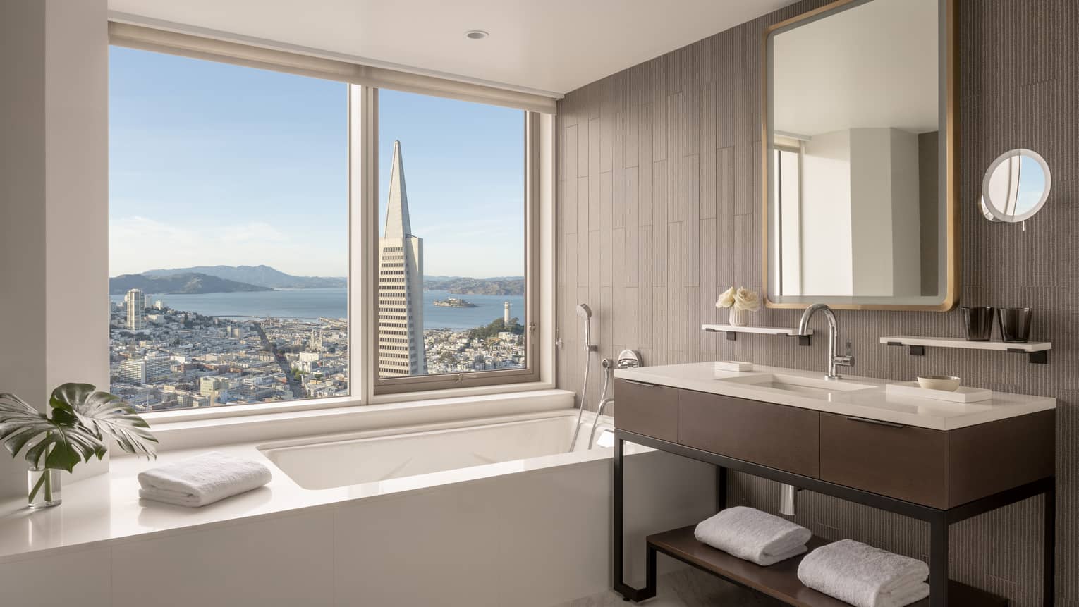 Hotel bathroom, featuring a window above the bathtub overlooking San Francisco
