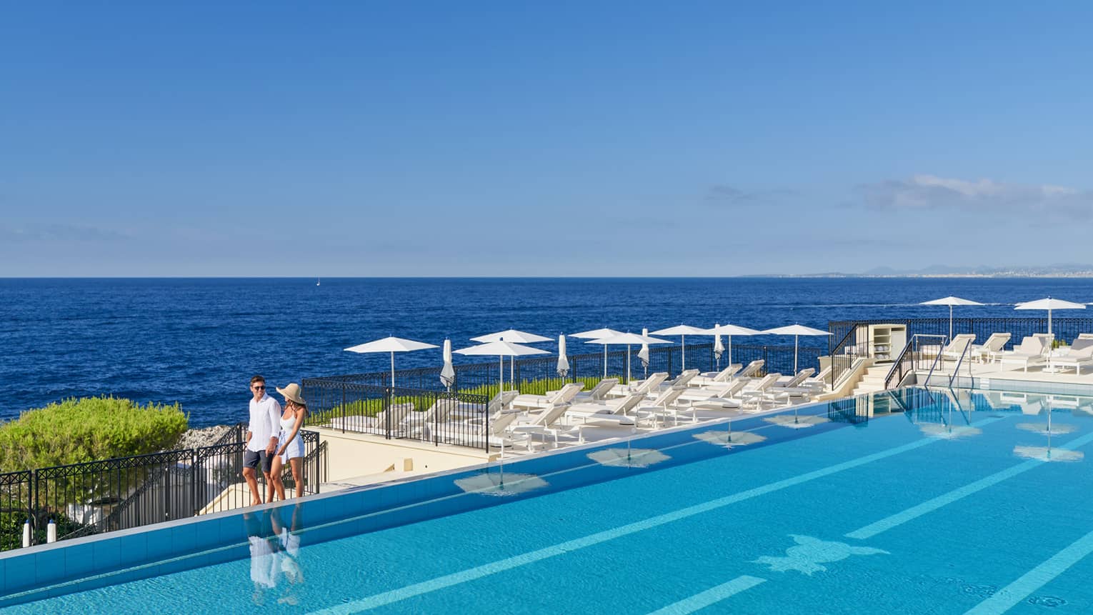 A couple walking around a luxury hotel pool