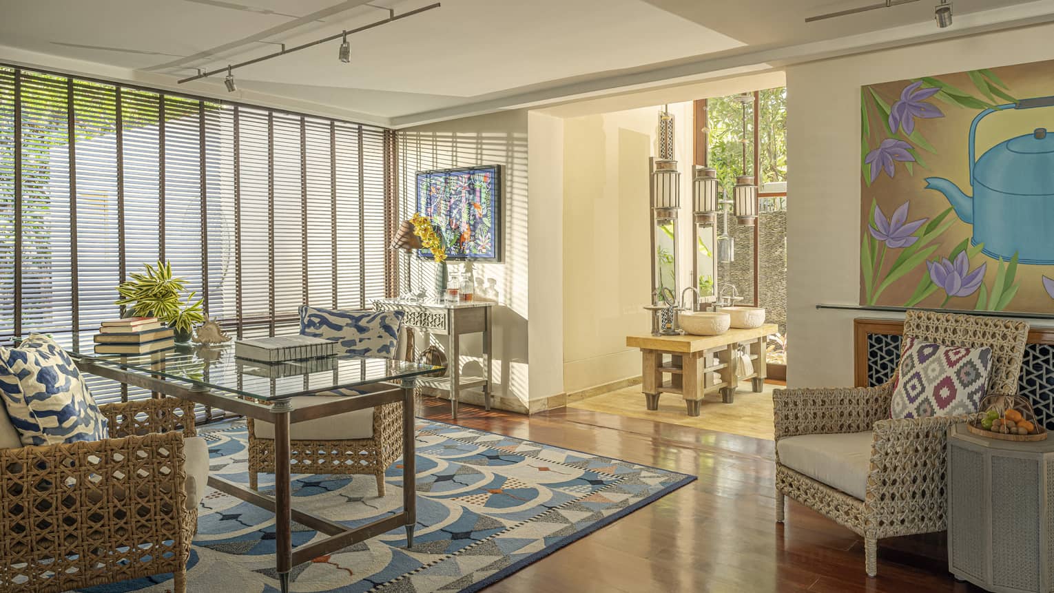 Office with glass desk, two rattan chairs, and an arm chair