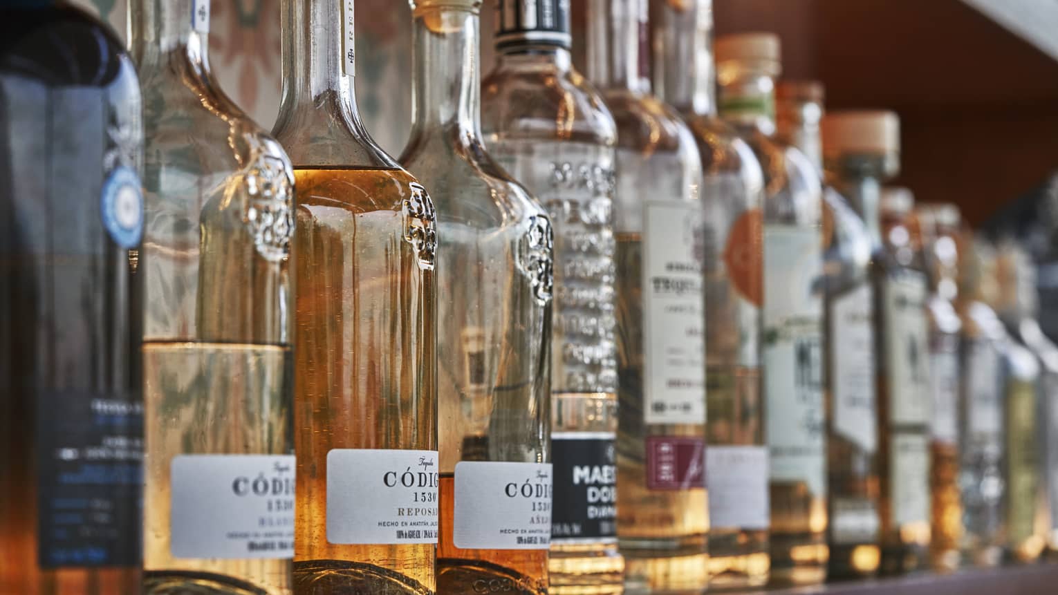 A row of wine and liquor bottles on a shelf.