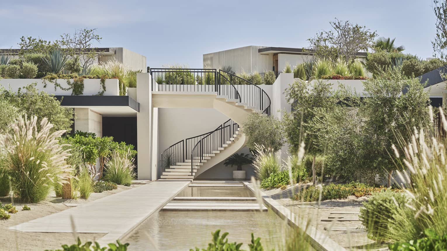 An outside courtyard with spiral stairs and plants.