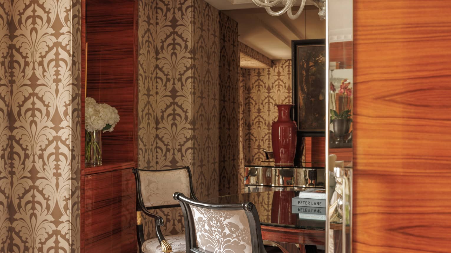 Dining room of Presidential Suite at Four Seasons Hotel London, featuring a round table with four chairs, wall paper and chandelier