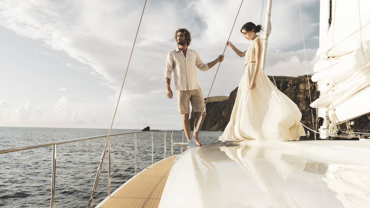 Man and woman stand on deck of catamaran while at sea in Lanai