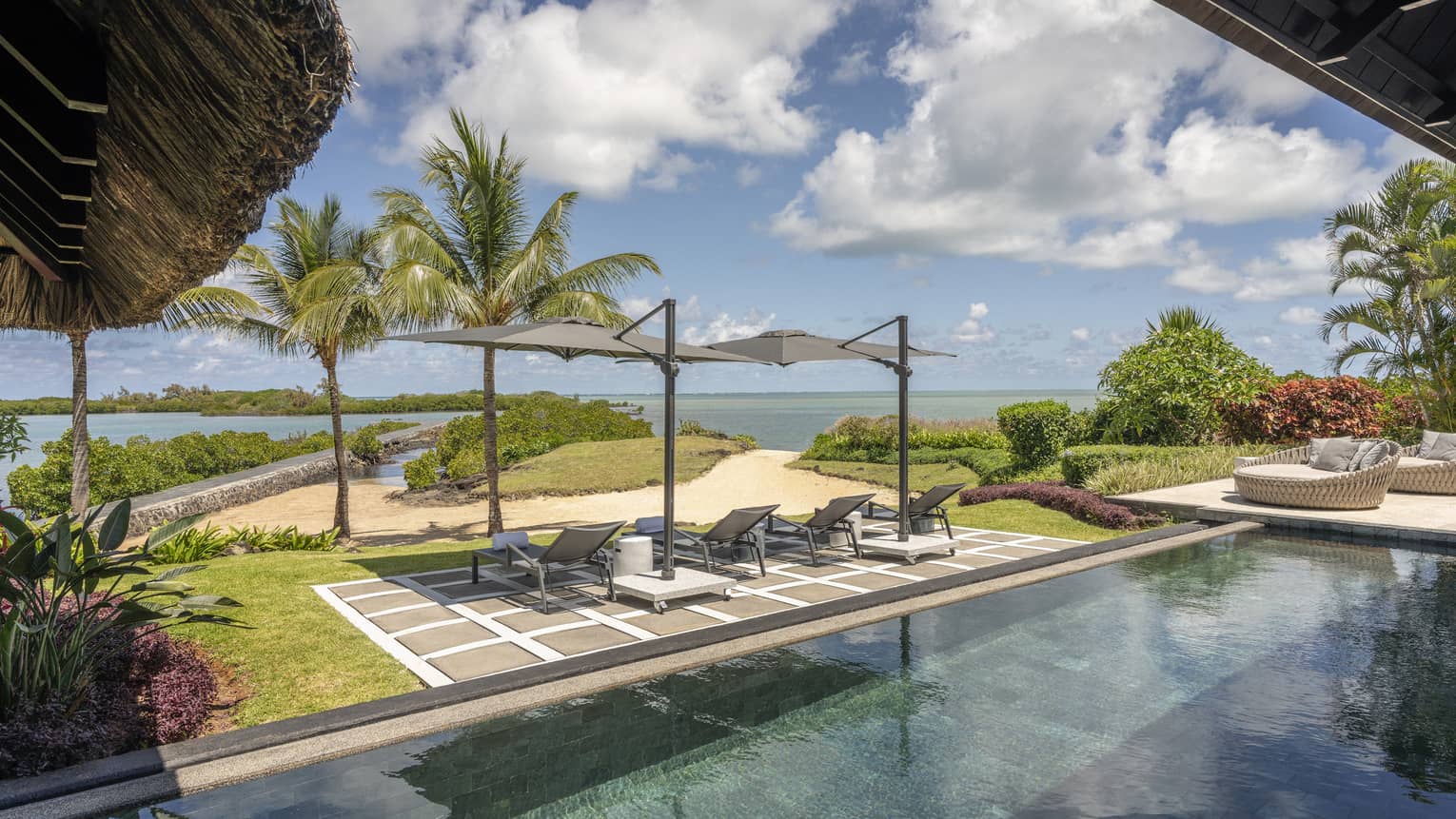 Pool and terrace with two umbrellas and four lounge chairs