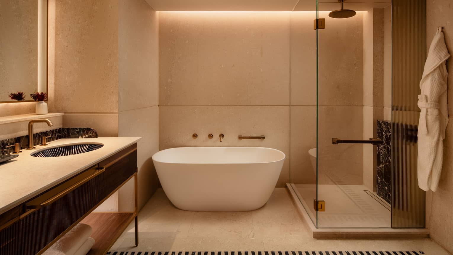 Luxury hotel room bathroom featuring a glass-enclosed shower and standalone deep soaking tub