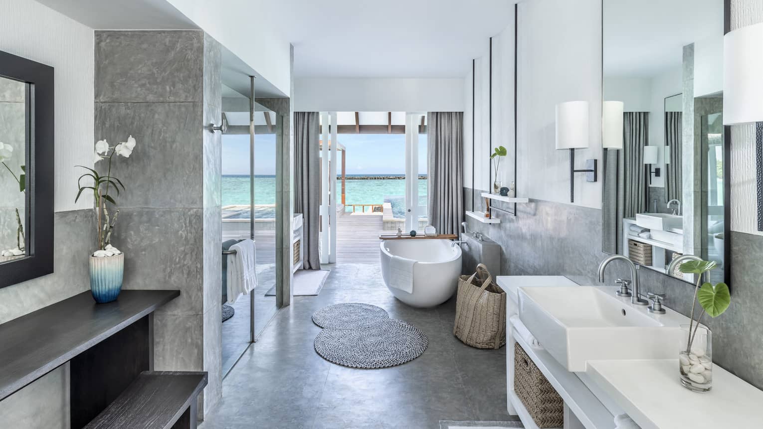 Bathroom with single vanity, large soaking tub and glass door shower, doorway to pool deck
