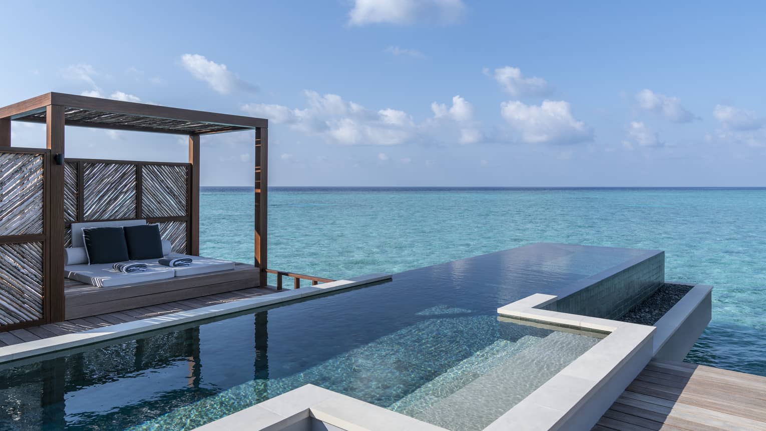 An oceanside infinity pool with a covered cabana 