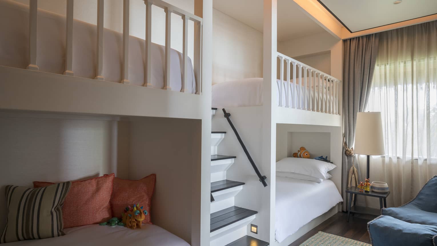 Bunk beds, pillows on either side of small staircase in children's room