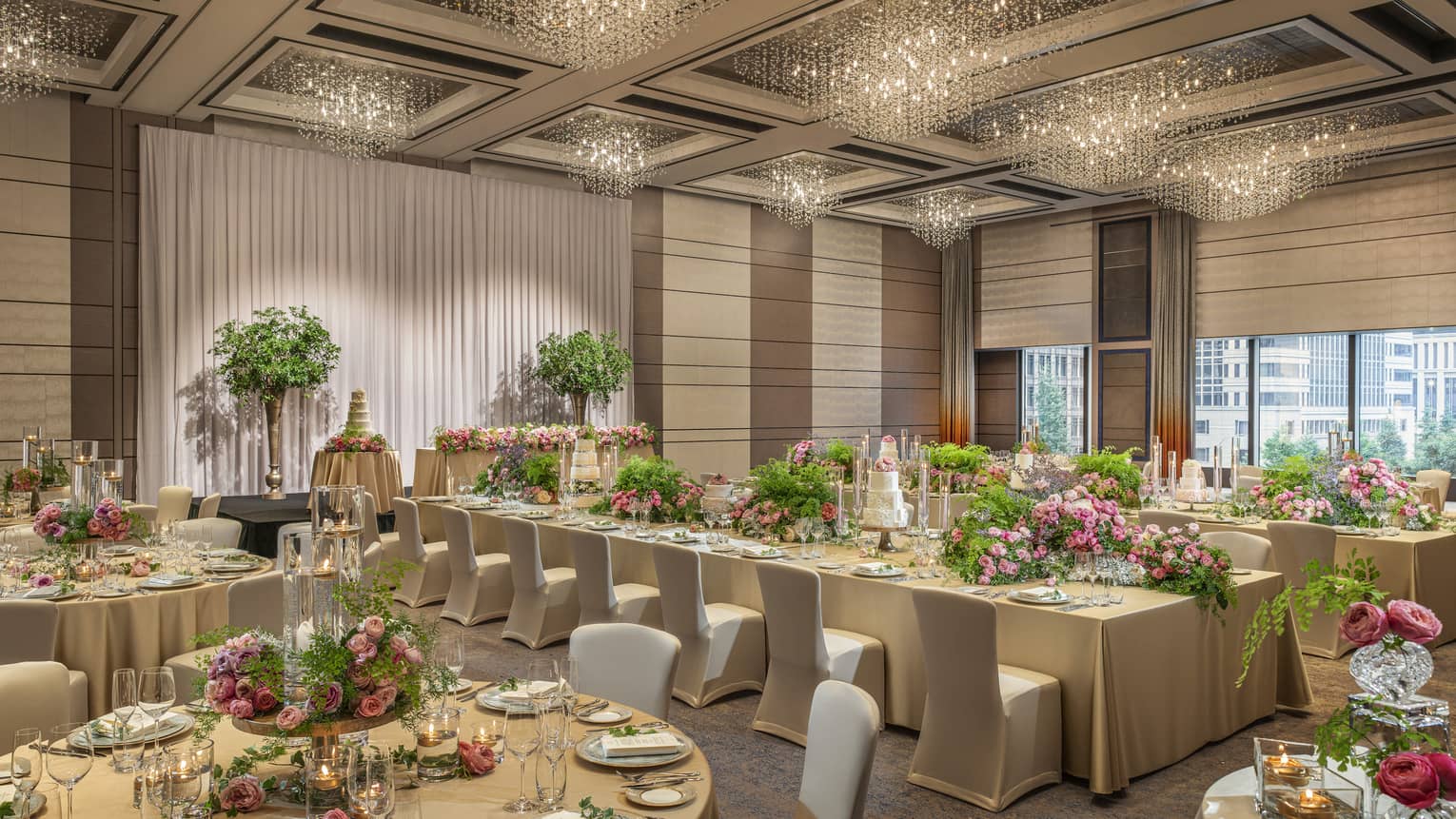Ballroom set for a wedding with gold tablecloths and pink floral centrepieces