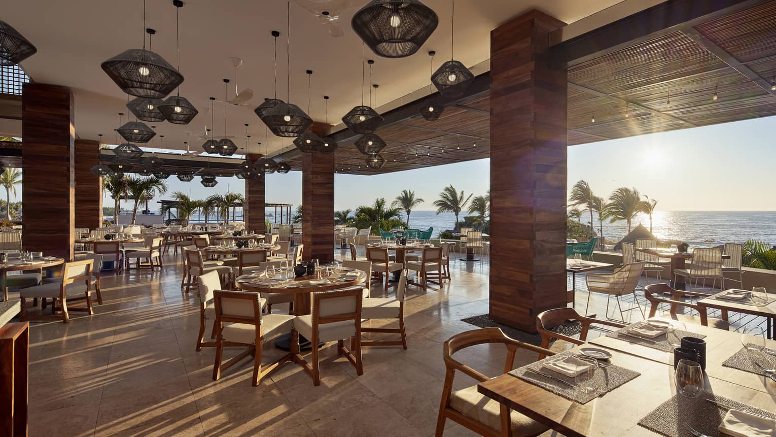 Sun streams into open air dining room with modern wood pillars 