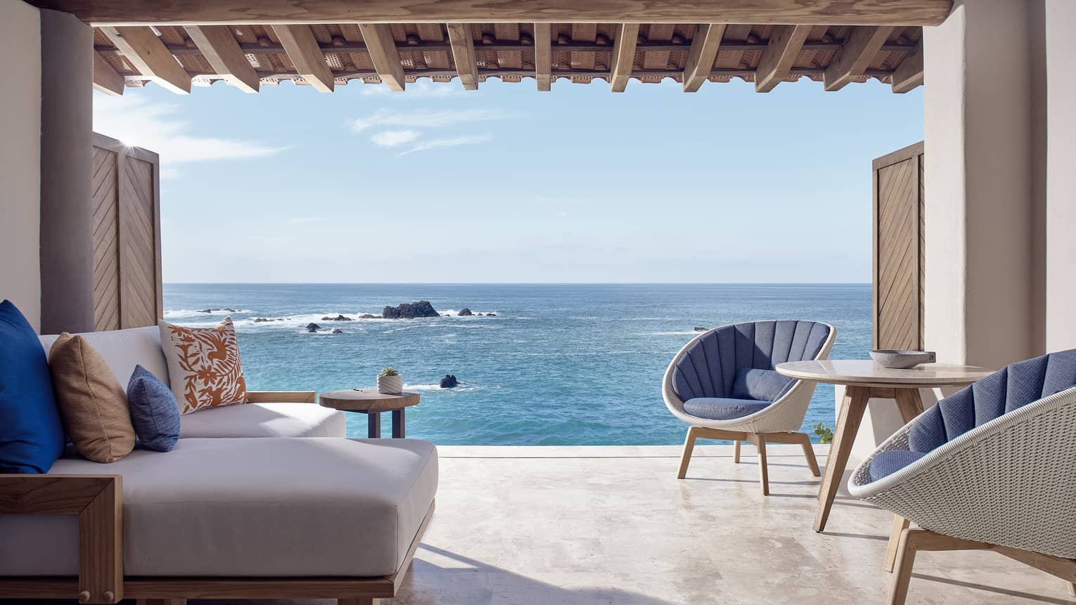 Sitting area with two chairs and one sofa, opening to the sea