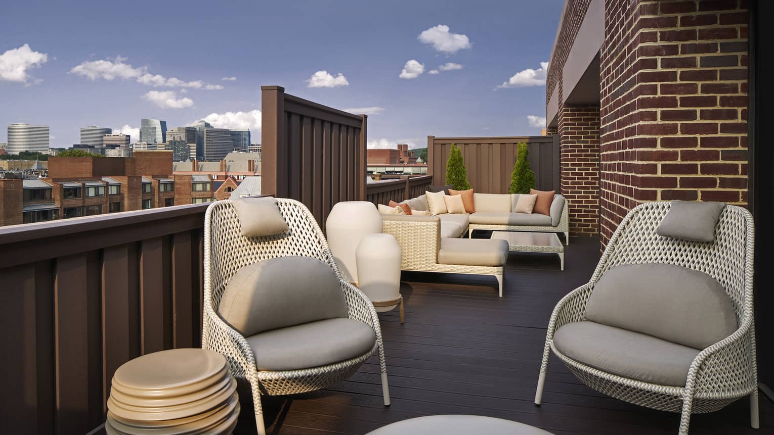 A large, outdoor terrace with cozy chairs and couches