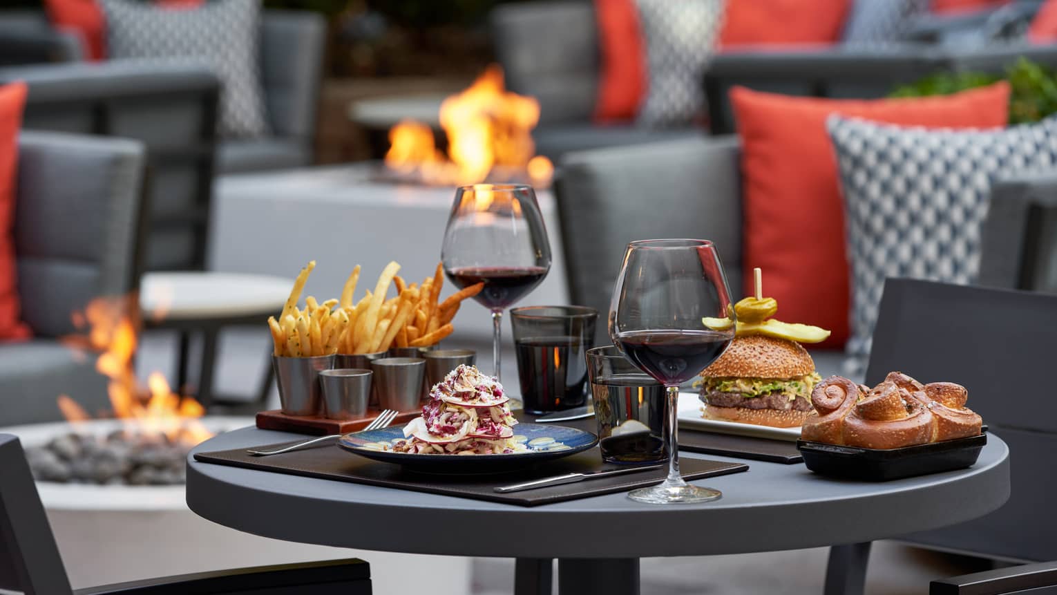 An assortment of food including fries and burger on a table outside.