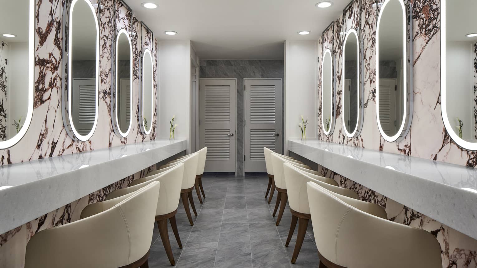 Modern luxury hotel spa with two walls of illuminated mirrors and chairs