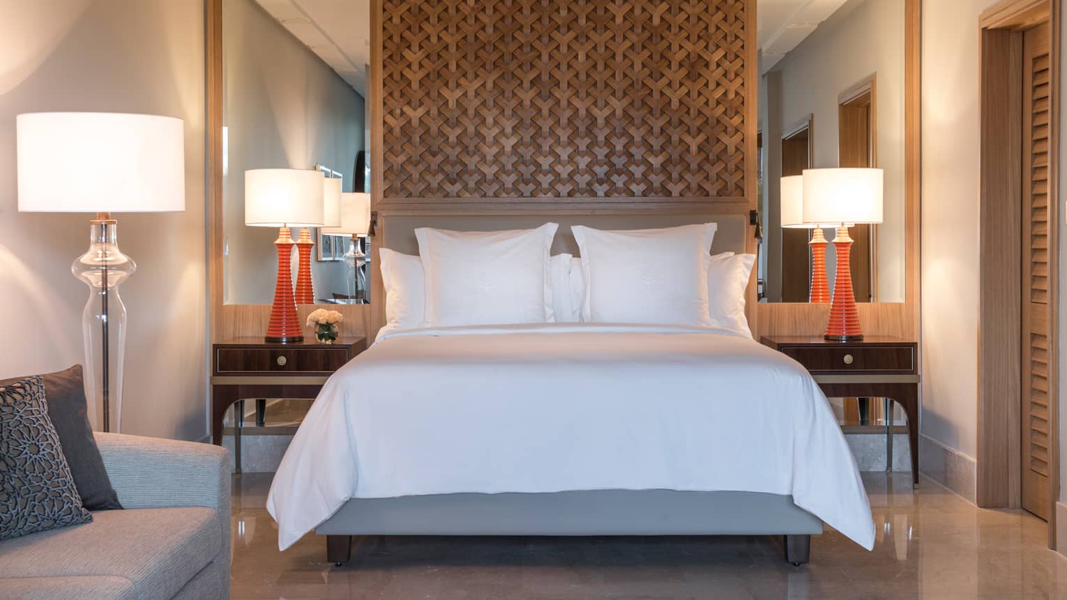 Superior Room bed under lattice wood panel, red lamps on nightstands, sofas