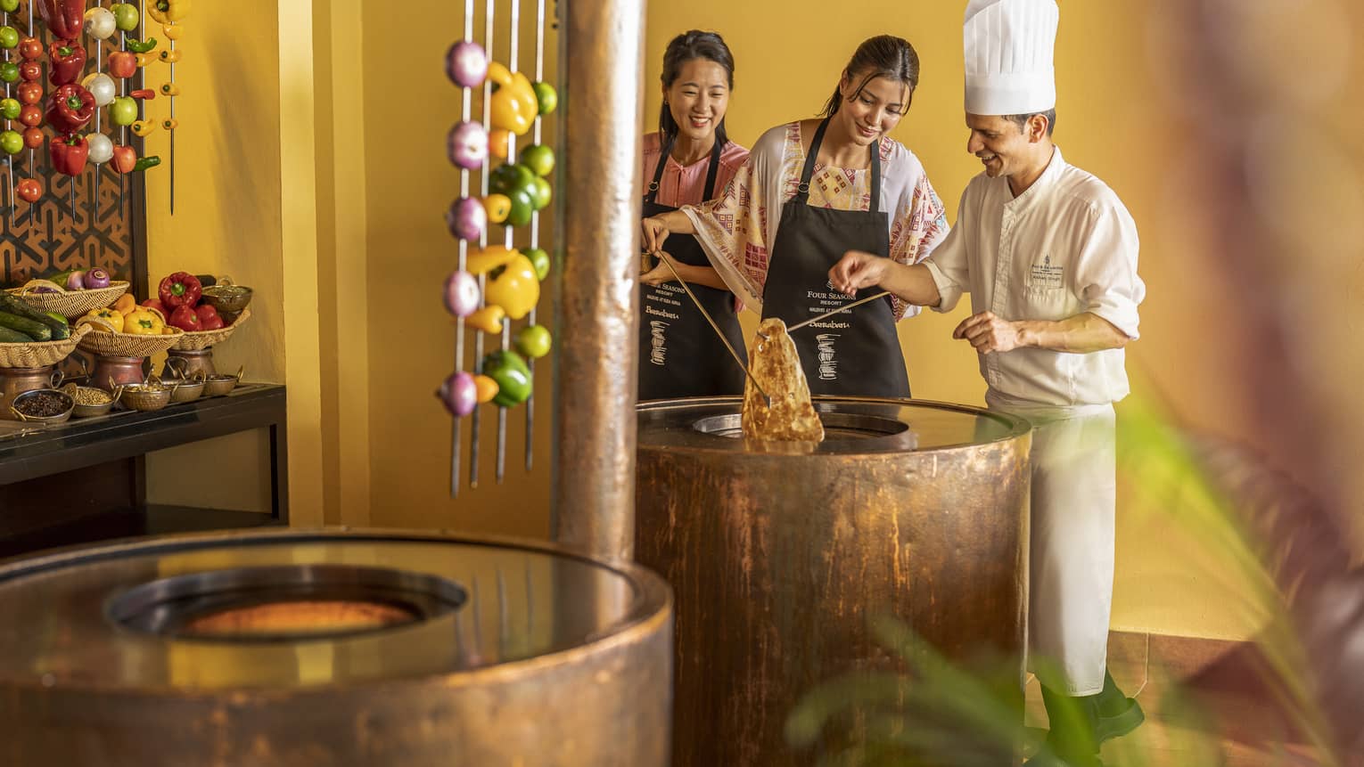 Chef teaches two female guests during Indian cooking class at Baraabaru