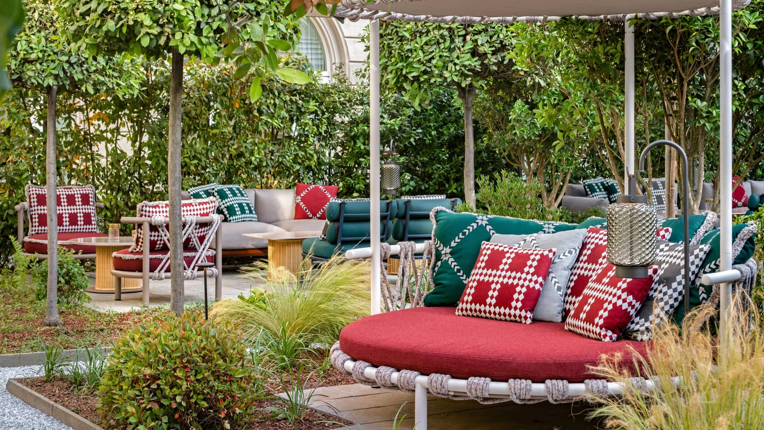 Garden courtyard with red, round covered seating and red-green decor