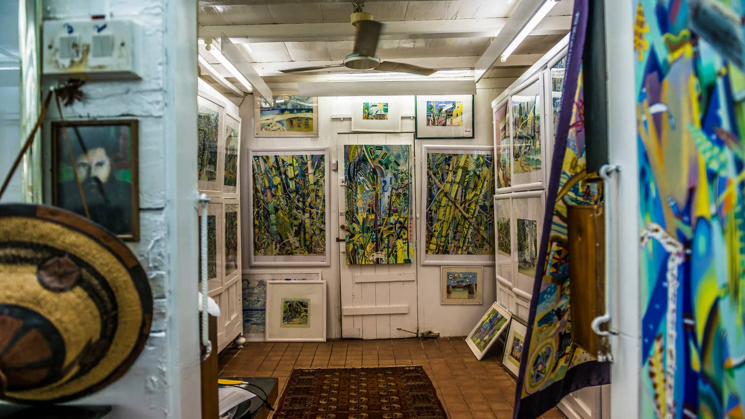 Interior of Michael Adams Gallery with colourful paintings on white walls 