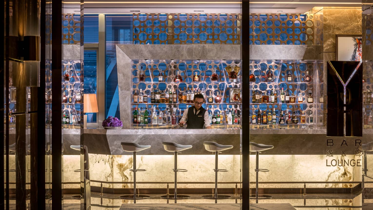 Yi bar and lounge bartender at modern illuminated white marble bar 