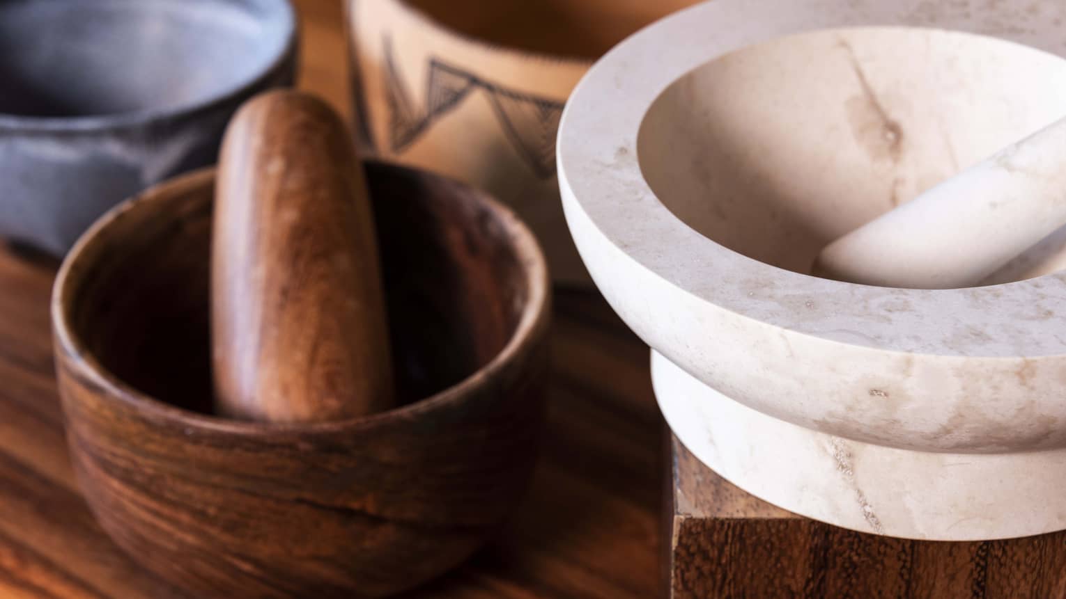 One wooden and one marble mortar and pestle
